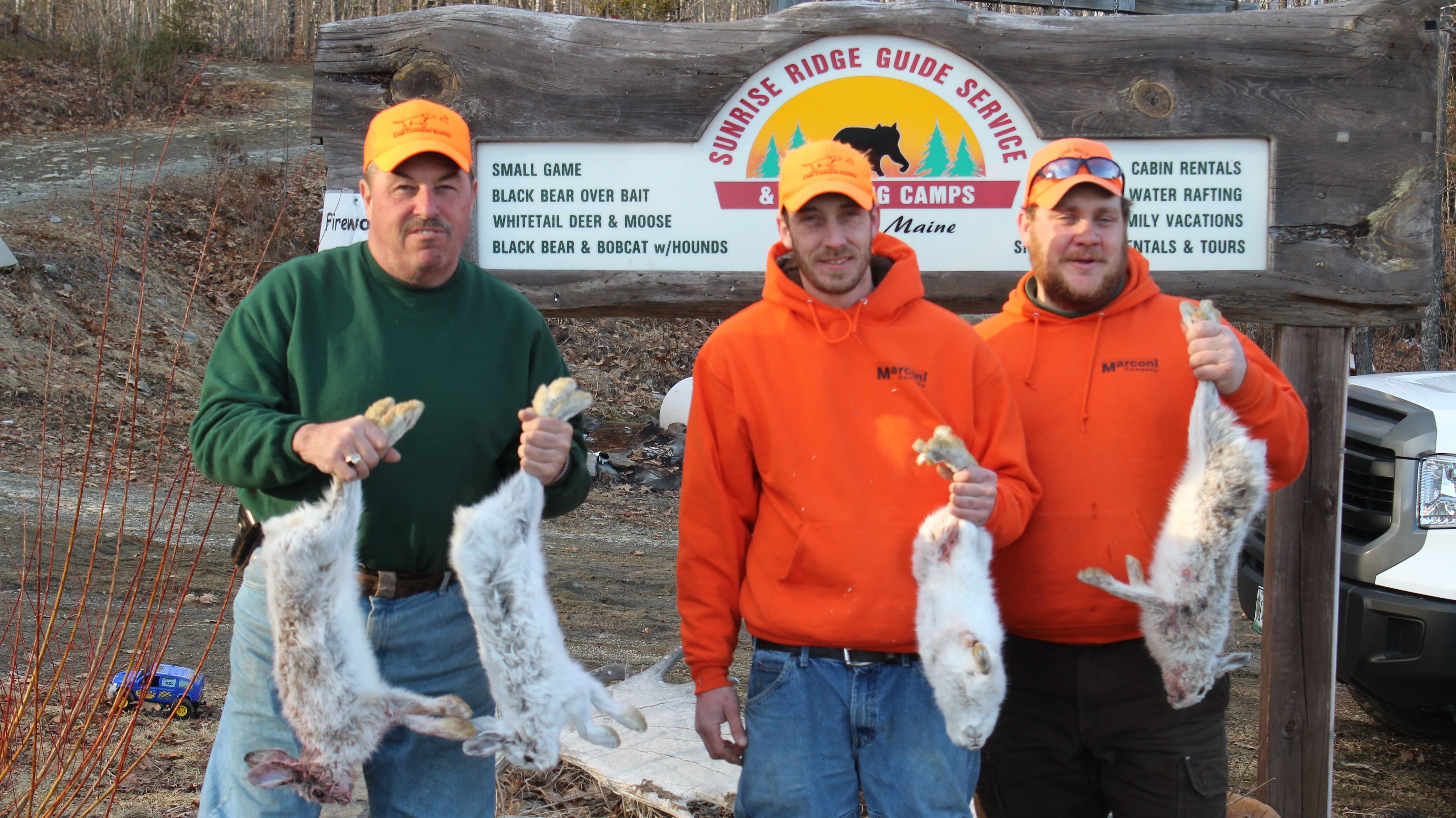 People Holding Dead Snowshoe Hare