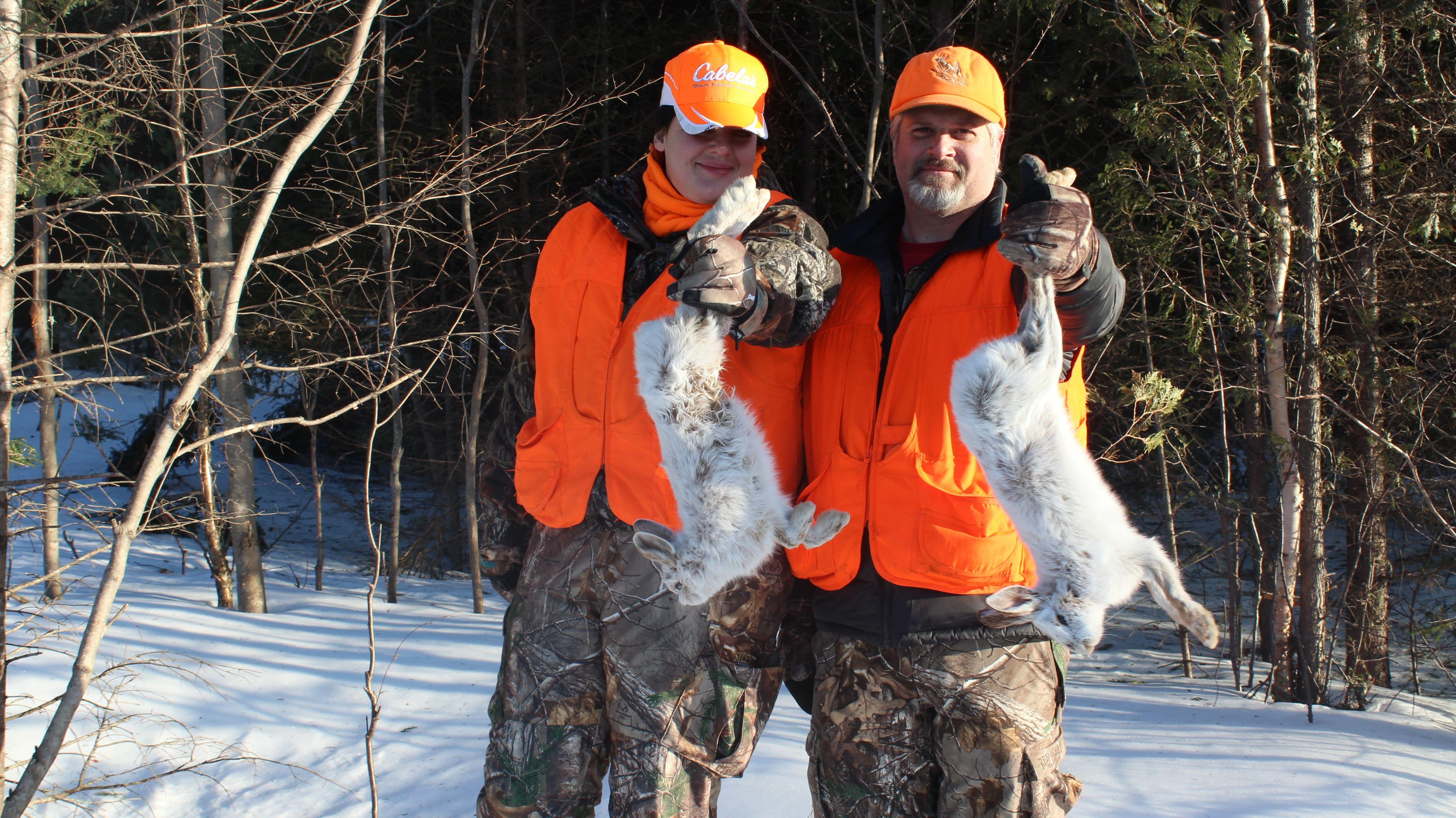 Two Men Holding Dead Snowshoe Hare